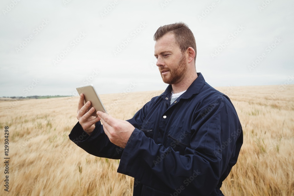 Poster farmer using digital tablet in the field