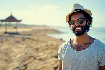 Handsome and confident. Outdoor portrait of smiling young african man on the beach.