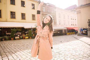 Naklejka premium Cheerful joyful young woman standing in old city
