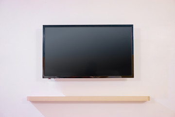 Black tv screen on white wall.