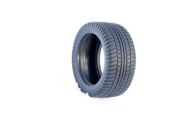 Black rubber tire rolling on the soft, fresh snow in the sunny day. White background. Seasonal tire change.