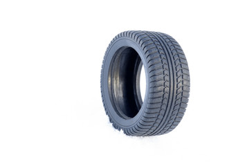 Black rubber tire rolling on the soft, fresh snow in the sunny day. White background. Seasonal tire...