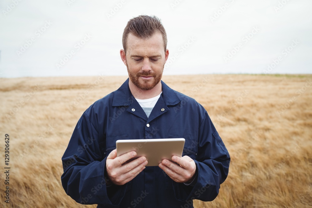 Poster farmer using digital tablet in the field