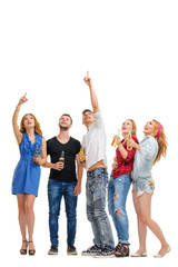 Obraz premium Your tex here. Party and relax. Group of amazed friends with bottles of beer looking up and pointing copy space. Isolated on white.
