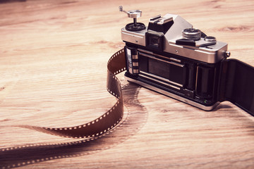 Old analog camera back door and photo film on wood background.  Roll of photographic film....
