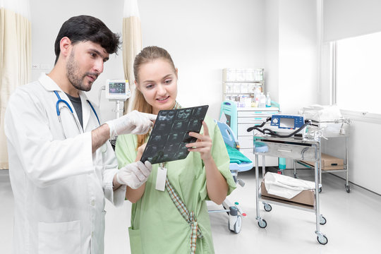 Doctor examining an x-ray film and discussing with a patient