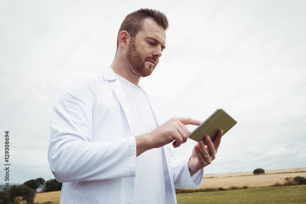 Poster agronomist using digital tablet in the field
