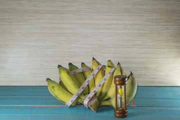 Hourglass with the tape measure and fruit shows the weight control.it take