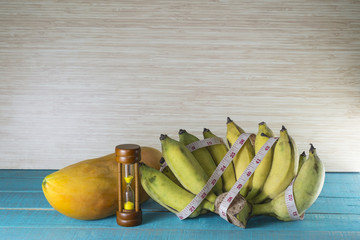 Hourglass with the tape measure and fruit shows the weight control.it take