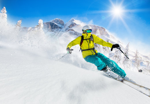 Skier skiing downhill in high mountains