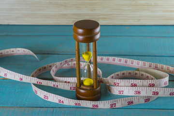 Hourglass with the tape measure shows the weight control.it take