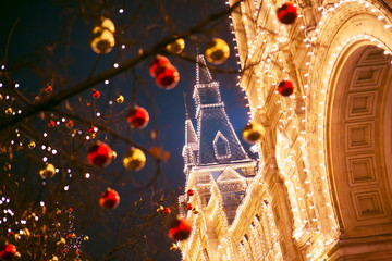 The store GUM on the background of trees decorated with Christmas balls. Red Square. Night. Moscow, Russia.