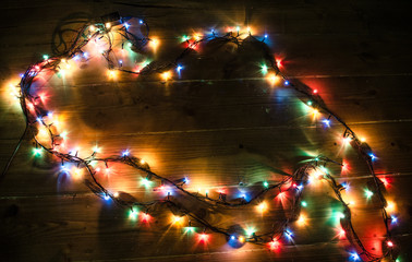 Christmas background with lights and free text space. Christmas lights border. Glowing colorful Christmas lights on black background. New Year. Christmas. Decor. Garland.