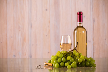 Bottle of white wine with grapes on glass
