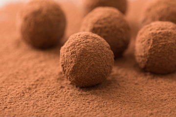 Close up of group of appetizing black chocolate truffles covered