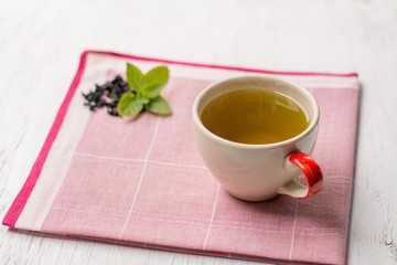 Closeup Herbal peppermint tea outdoor summer green leaves,Tea cup with mint leaves on wood background.