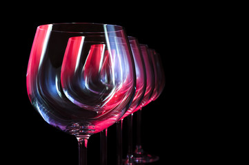 Party wine glasses in nightclub lit by red, blue, lilac lights, nightlife and entertainment...