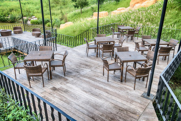 The wood table on natural outdoor of a restaurant with tree and