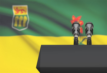 Pulpit and two microphones with Canadian province flag on background - Saskatchewan