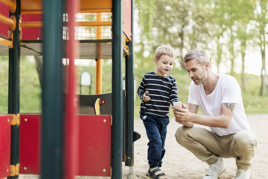 Father with son at playground - Powered by Adobe