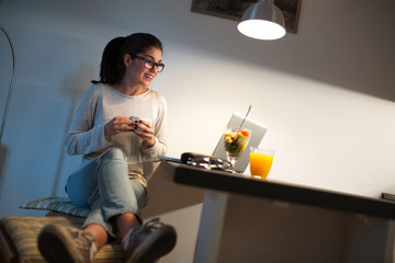 Young female blogger working at home.She sitting in her working room and typing something on laptop.