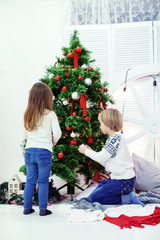 little brother and sister near Christmas tree. 