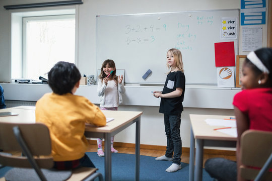 Students explaining to classmates in classroom