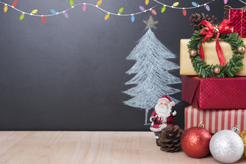 Christmas table with decorations and gift box on christmas tree background.