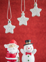 Silver star hang on red blur background with snowman and Santa c