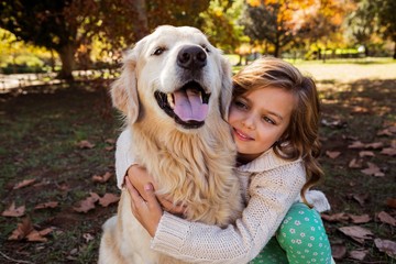 Little girl embracing her dog