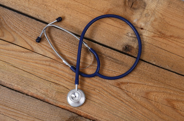 Closeup of a medical stethoscope, isolated on wooden background