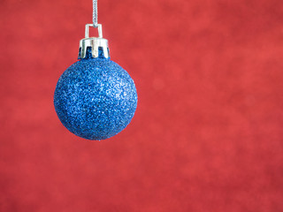 Blue Christmas ball hang on red blur background 1