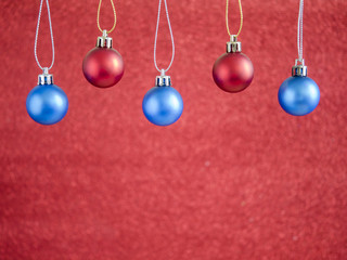 Red and blue christmas ball hang on red blur background 1