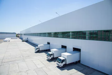 Fotobehang Industrieel gebouw gevel van een industrieel gebouw en magazijn met goederenwagons in de lengte