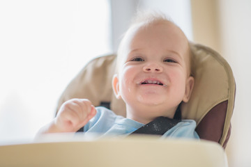 baby sitting on a chair and laughing mom