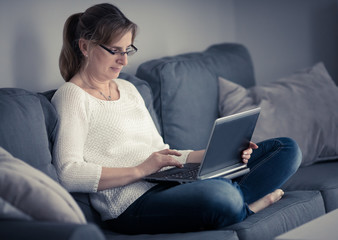 Middle-aged woman using laptop at home 