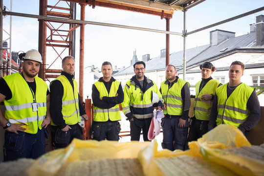 Portrait of confident manual workers standing at construction site