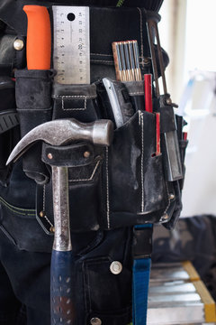 Midsection of construction worker wearing tool belt