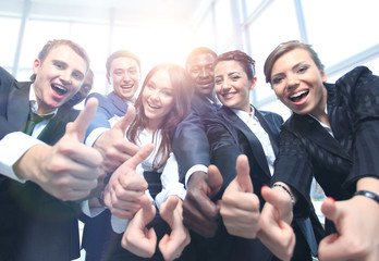 Happy multi-ethnic business team with thumbs up in the office