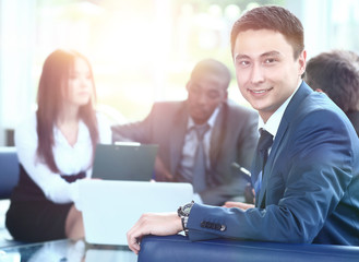 Confident young business man attending a meeting with his colleagues