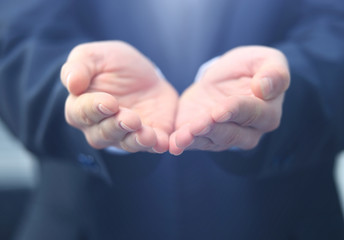 Businessman give you secret about successful business. Giving and protecting gesture. Blue formal wear and background.