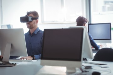 Mature student in virtual reality headset using computer