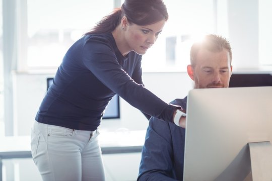 Teacher assisting mature student in computer room