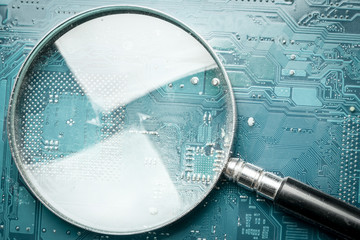 magnifier on a computer circuit board, with copy space for your inscription on a flare inside a magnifying glass.