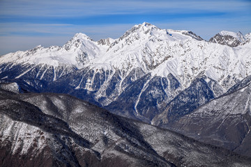 Beautiful mountain scenic winter landscape of the Main Caucasian ridge with snowy peaks and blue sky