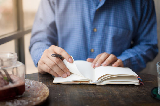 Adult freelance businessman writing on notebook
