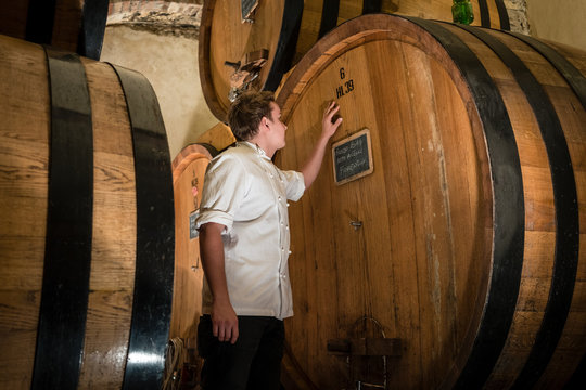 Chef inspecting wine in a wine cellar