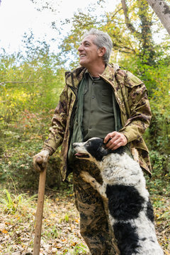 Man and his dog on truffle hunt in woods of Tuscany, Siena, Ital