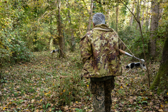 Truffle hunter and his dog walking through the woods searching f