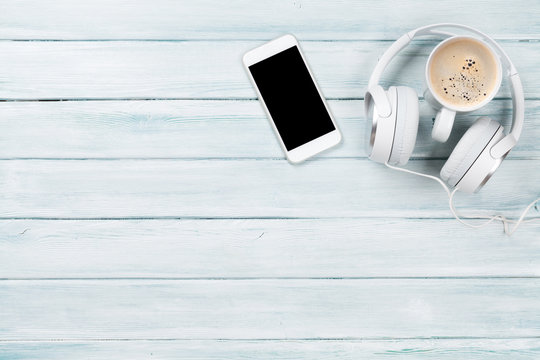 Smartphone, headphones and coffee cup
